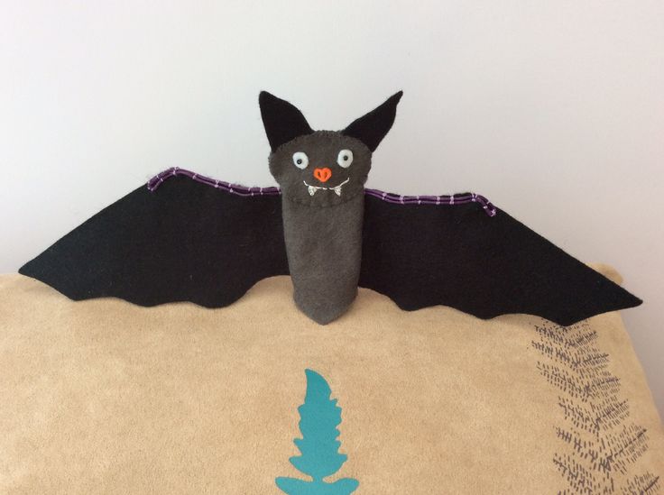 a stuffed bat sitting on top of a bag