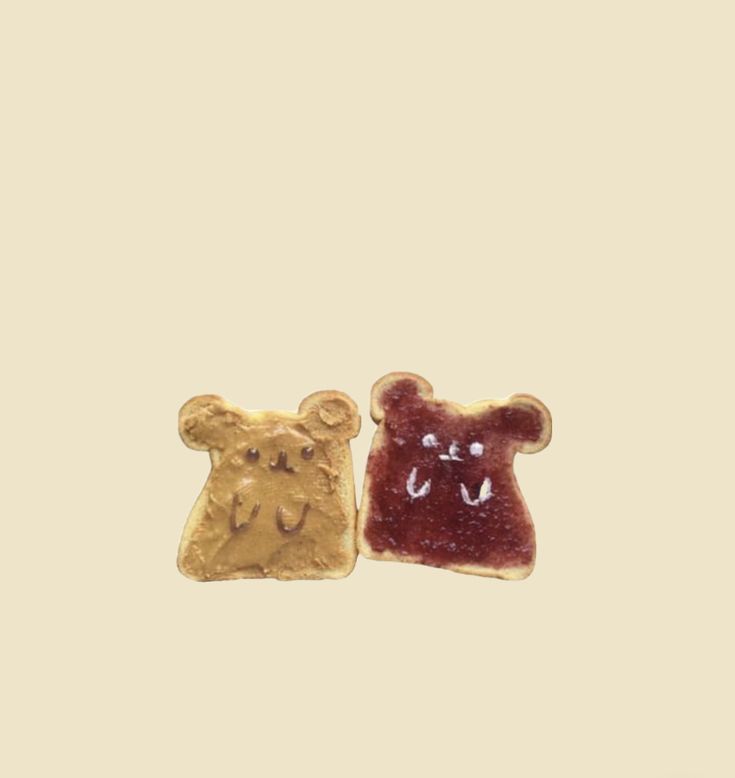 two gold and red teddy bears are on a beige background, one is wearing a bear earring