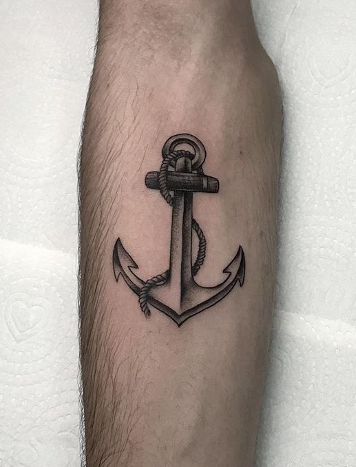 a black and white anchor tattoo on the leg