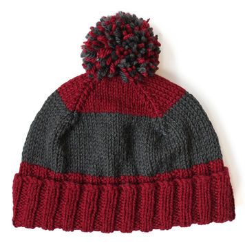 a red and grey knitted hat with pom - pom on the top