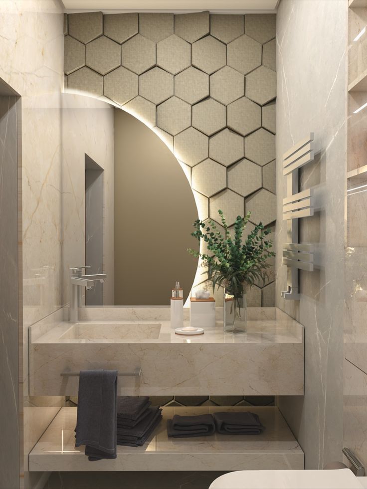 a bathroom with a toilet, sink and mirror in it's corner area that has hexagonal tiles on the wall