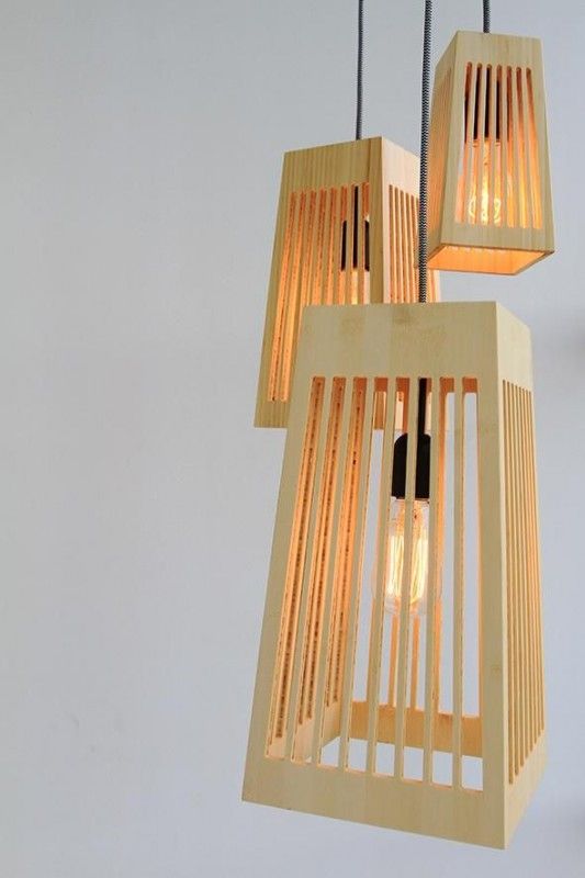 three wooden lights hanging from the ceiling in a room with white walls and flooring