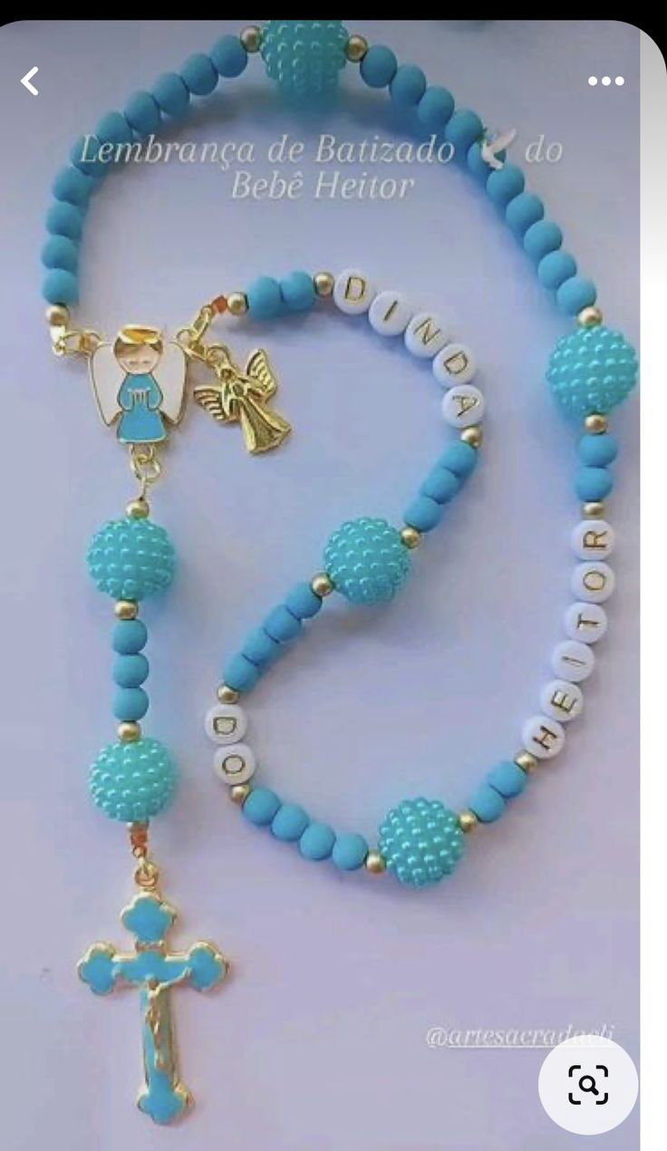 a blue beaded necklace with a gold cross and an angel charm on the clasp