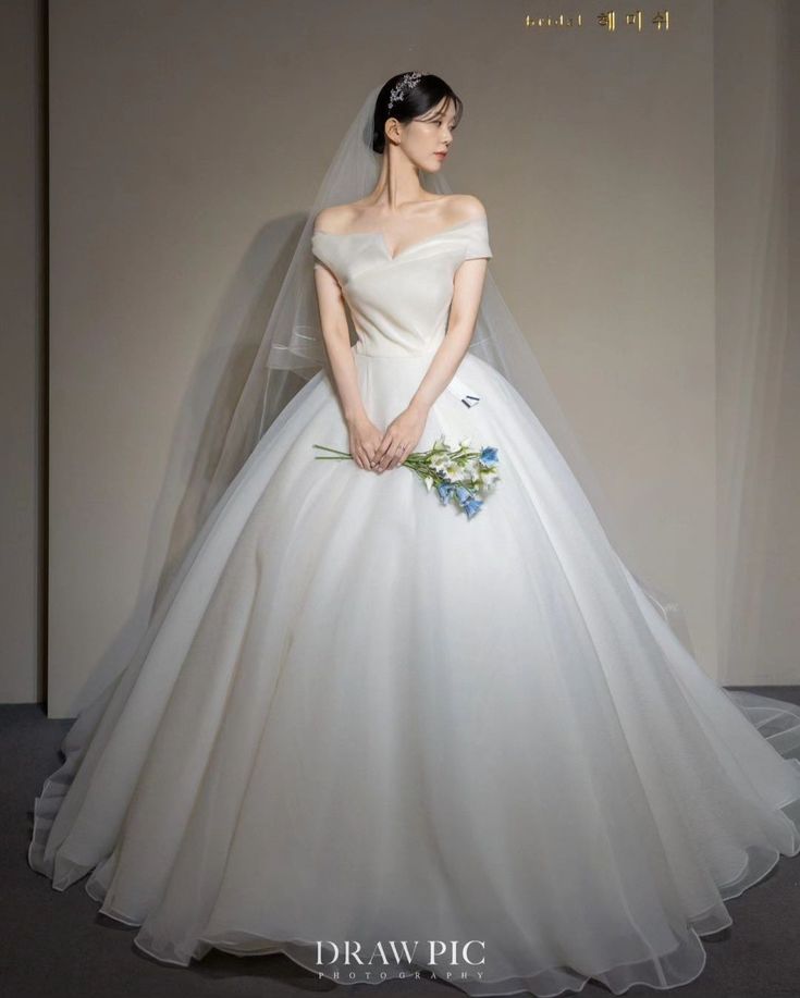 a woman in a white wedding dress standing on a runway