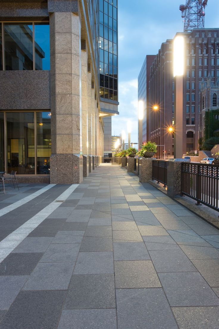 an empty sidewalk in front of some tall buildings