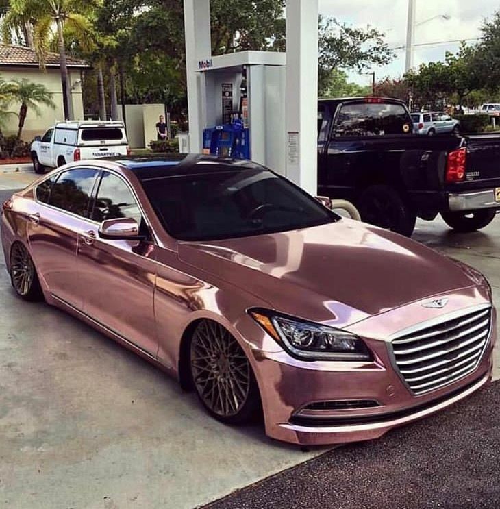 a pink car parked in front of a gas station