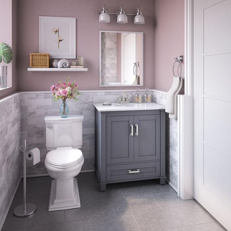 a bathroom with a toilet, sink and mirror in it's center wall is shown