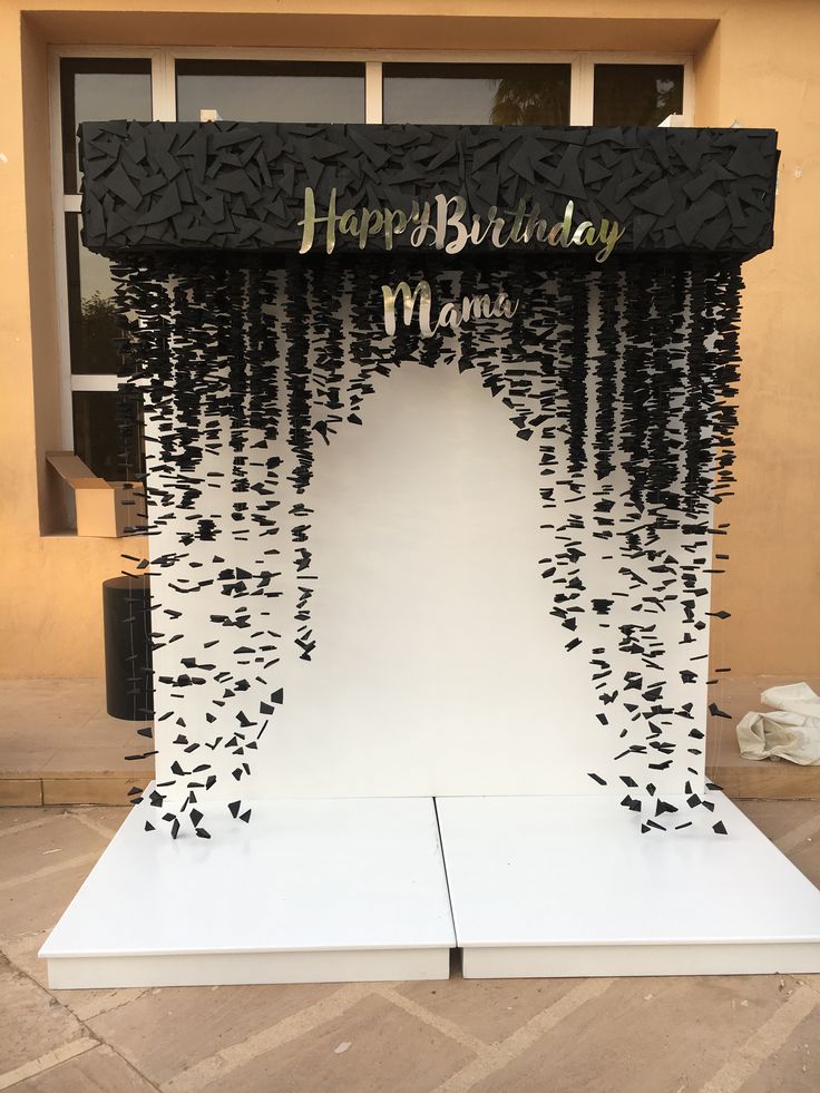 a black and gold happy birthday mandap on display in front of a building