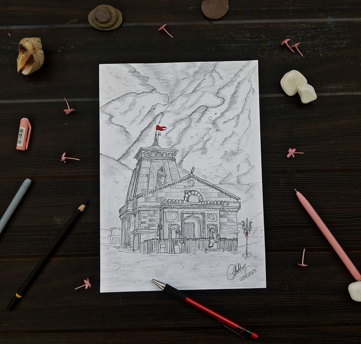 a drawing of a building with mountains in the background and crayons around it