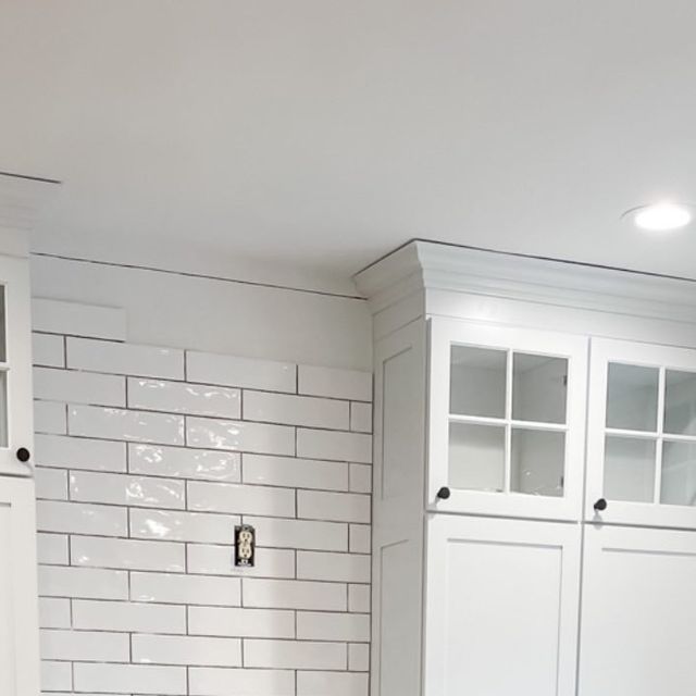 a kitchen with white cabinets and black counter tops