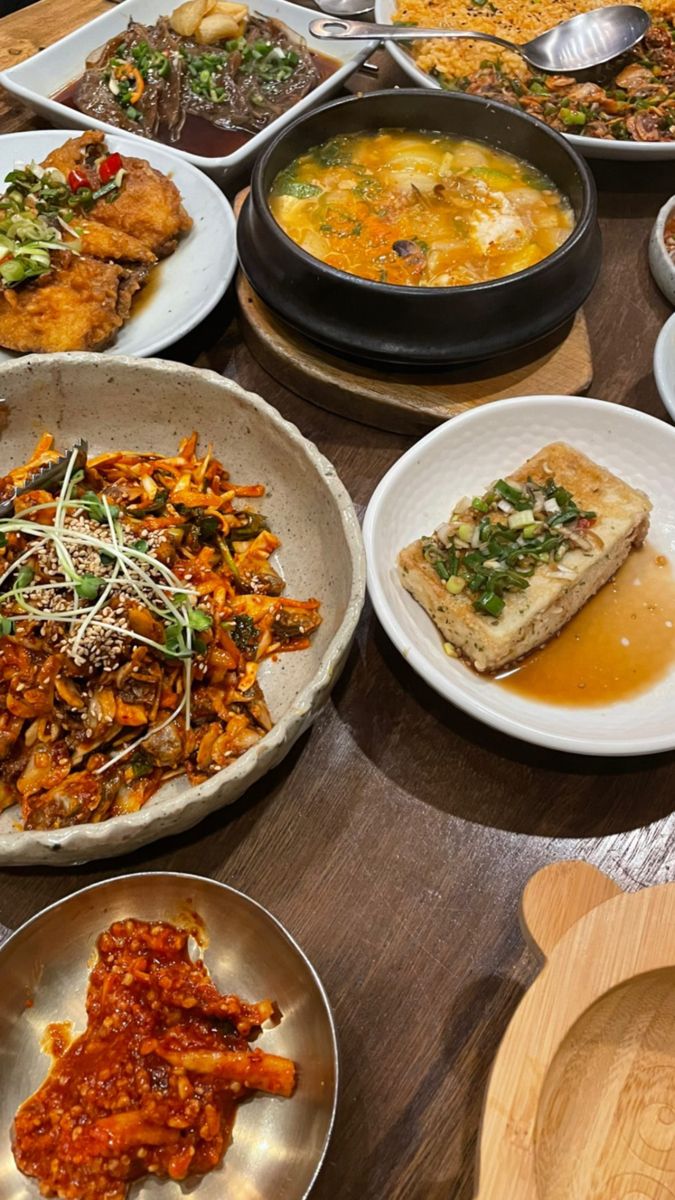 a table topped with lots of plates and bowls filled with different types of food on top of it