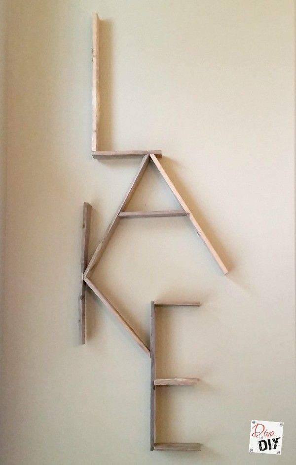 a sculpture made out of wood sticks on top of a white wall