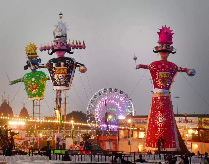 three carnival floats in the middle of an amusement park at night with ferris wheels and lights