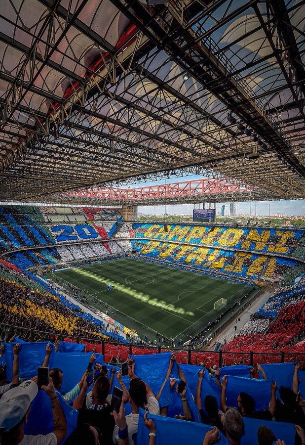 an empty soccer stadium with fans holding up their hands