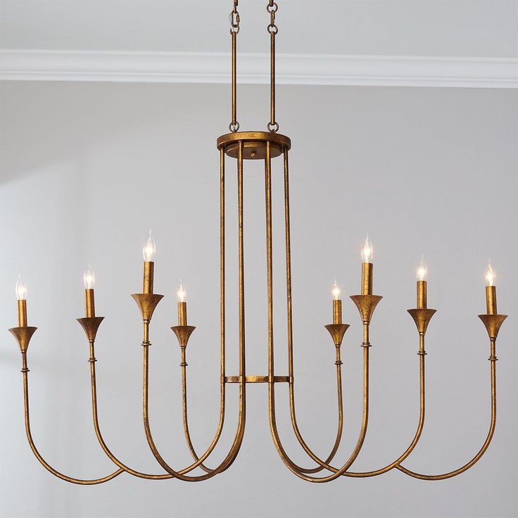 a gold chandelier with six candles hanging from it's center and four arms