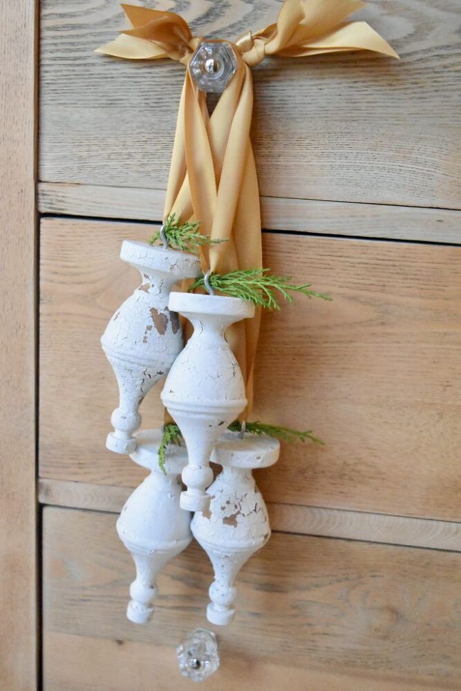 a cross made out of vases hanging on a wall with ribbons attached to it