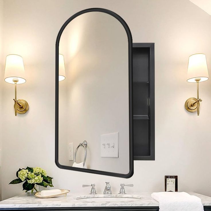 a bathroom with a sink, mirror and two lights on the wall next to it