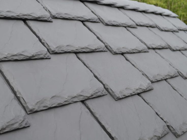 slate roof tiles on a house with grass in the background