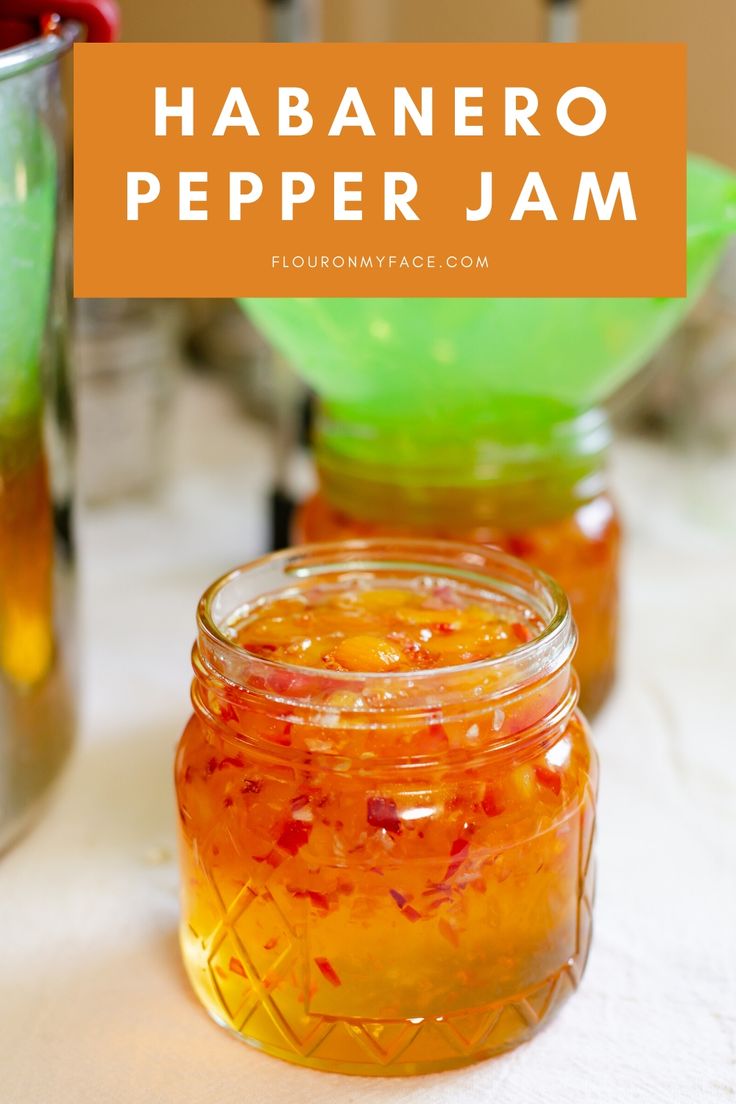 a jar filled with orange liquid sitting on top of a table next to other jars