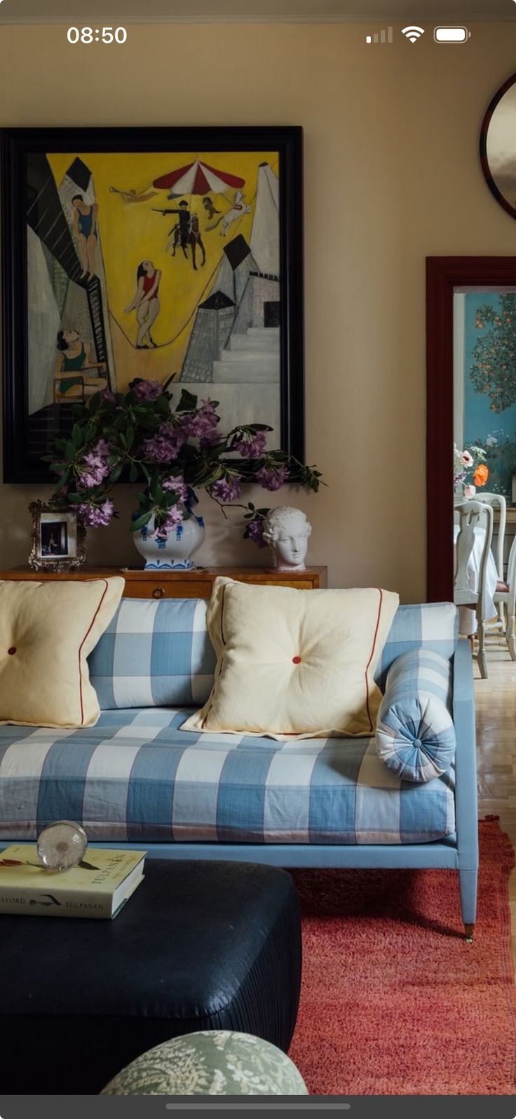 a blue and white checkered couch sitting in a living room next to a painting