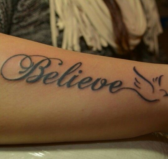 a person with a tattoo on their arm that says believe