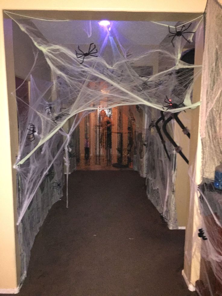 a hallway decorated for halloween with spider webs