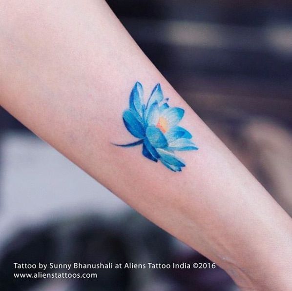 a blue flower tattoo on the arm