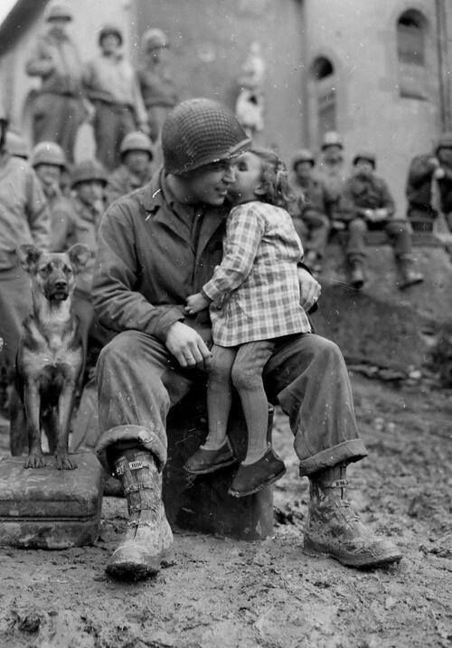 an old black and white photo of a man holding a small child in his lap