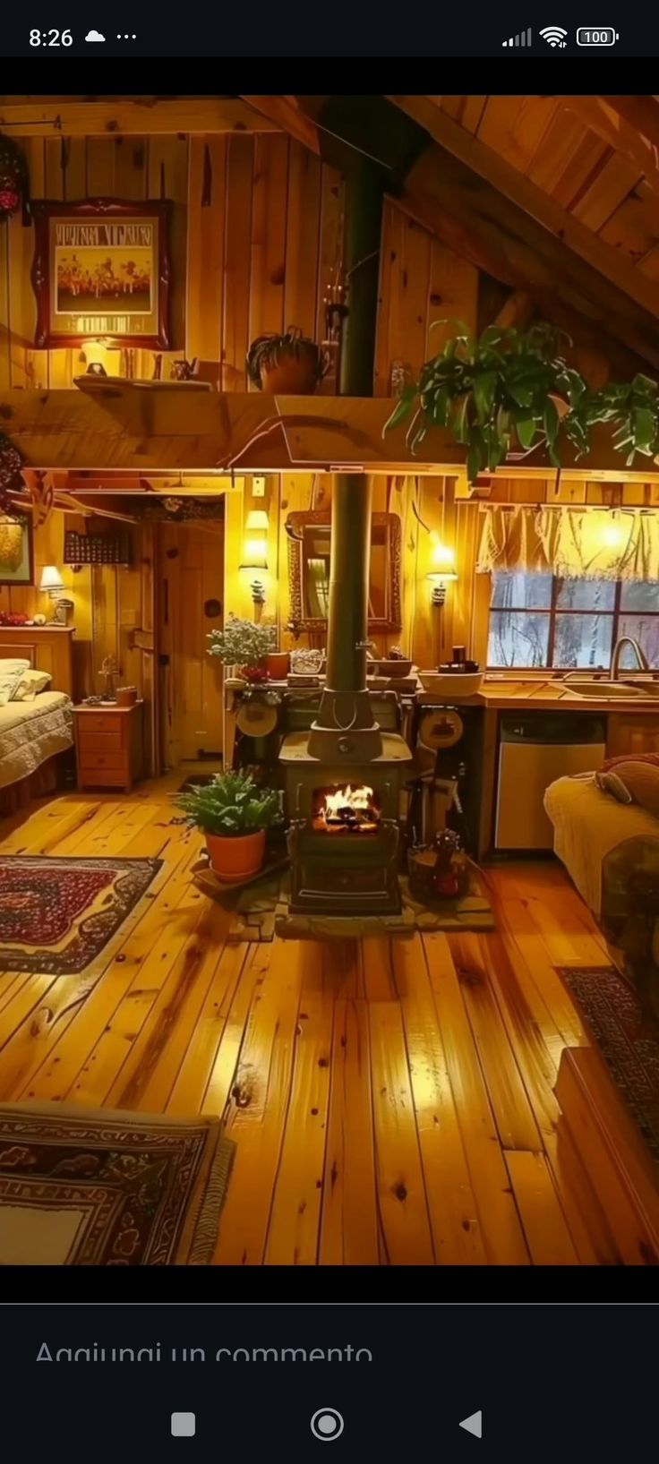 a room with wood floors and a stove in the center, surrounded by wooden walls