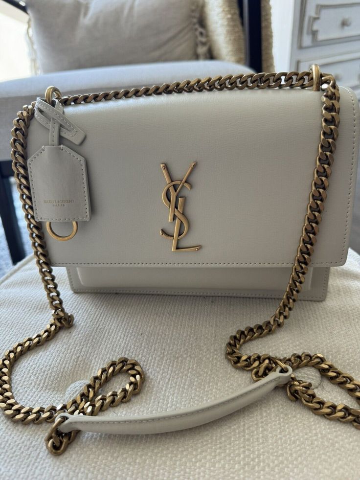 Very good condition Authentic Saint Laurent medium Sunset bag in off white with antique gold hardware. Fits a lot and is perfect for everyday wear or going out. Neutral color goes with every outfit. Very versatile, can be worn as shoulder bag or crossbody bag. Saint Laurent Sunset Bag, Neutral Color, White Bag, Cloth Bags, Ysl Bag, Neutral Colors, Smooth Leather, Antique Gold, Gold Hardware