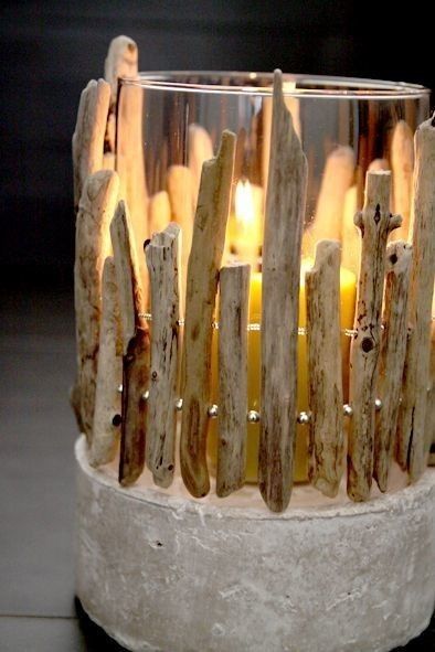 a candle holder made out of driftwood with candles in the center and on top