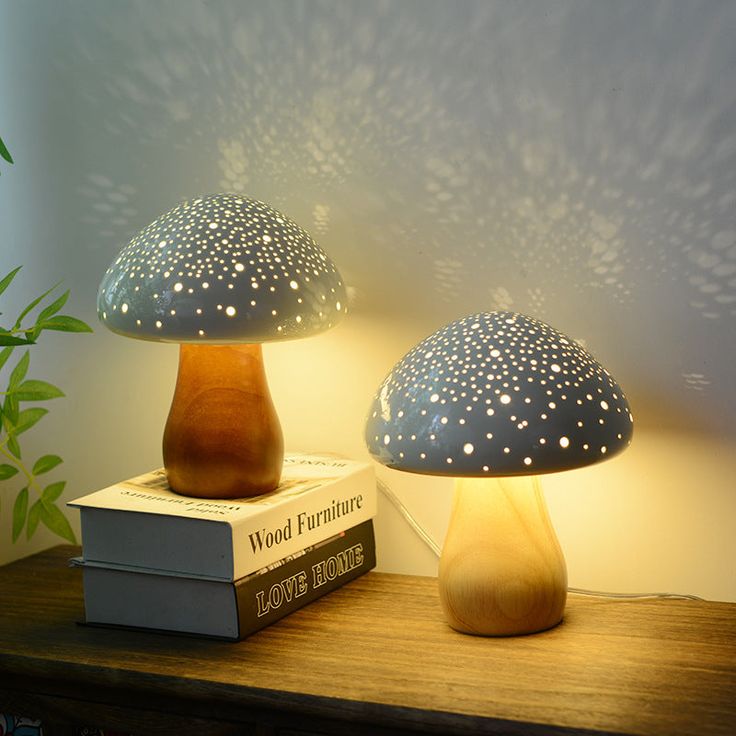 two blue and white mushrooms sitting on top of a wooden table next to a book