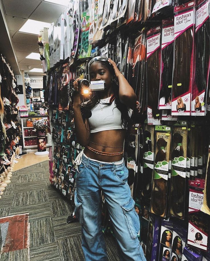 a woman taking a selfie in a store with her cell phone up to her ear