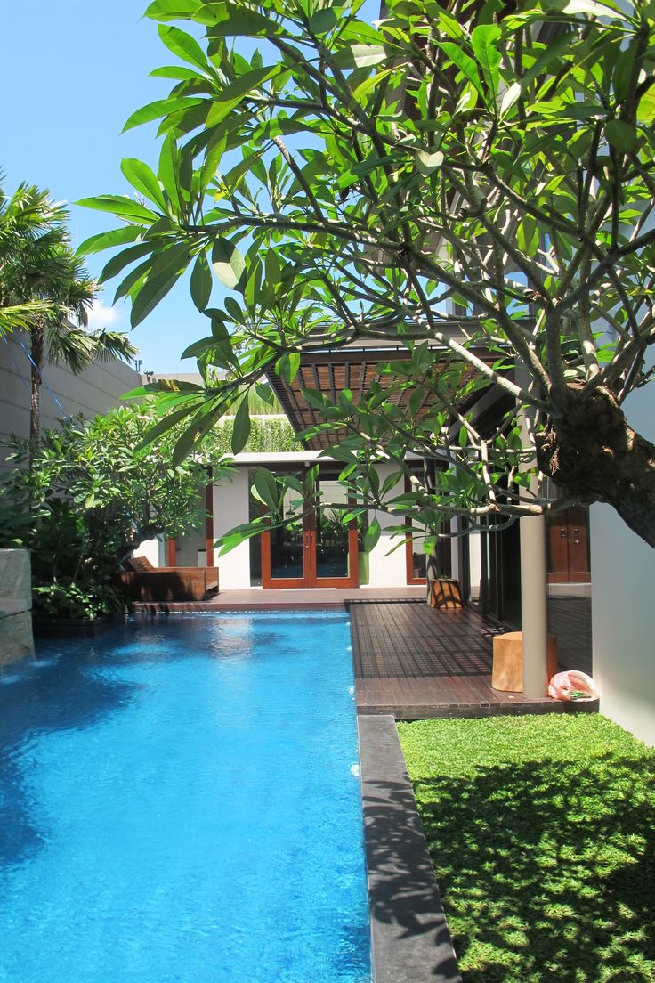 an outdoor swimming pool surrounded by trees and grass