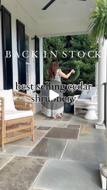 a woman standing on the front porch of a house