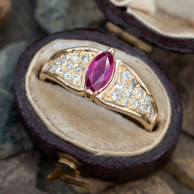 This lovely ring features a marquise cut ruby with pavé set round brilliant cut diamonds on each shoulder. The ring is crafted of 14k yellow gold and currently a size 6.5. Gold Marquise Ruby Ring, Marquise Ruby Promise Ring With Prong Setting, Marquise Ruby Ring With Rose Cut Diamonds For Wedding, Marquise Ruby Ring With Diamonds, Marquise Ruby Cluster Ring In Fine Jewelry Style, Marquise Ruby Cluster Ring Fine Jewelry, Red Marquise Ring With Diamond Accents, Gold Marquise Ruby Ring With Diamonds, Red Marquise Diamond Accent Rings