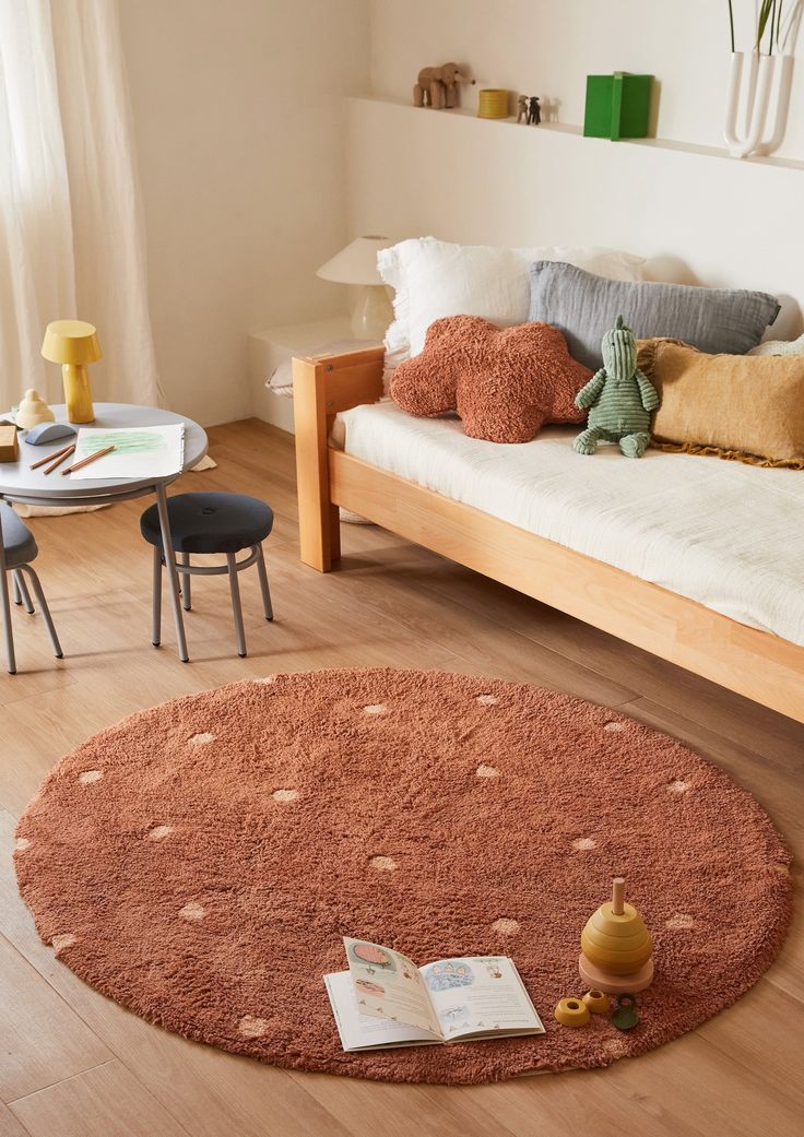 a living room with a couch, coffee table and books on the floor in front of it