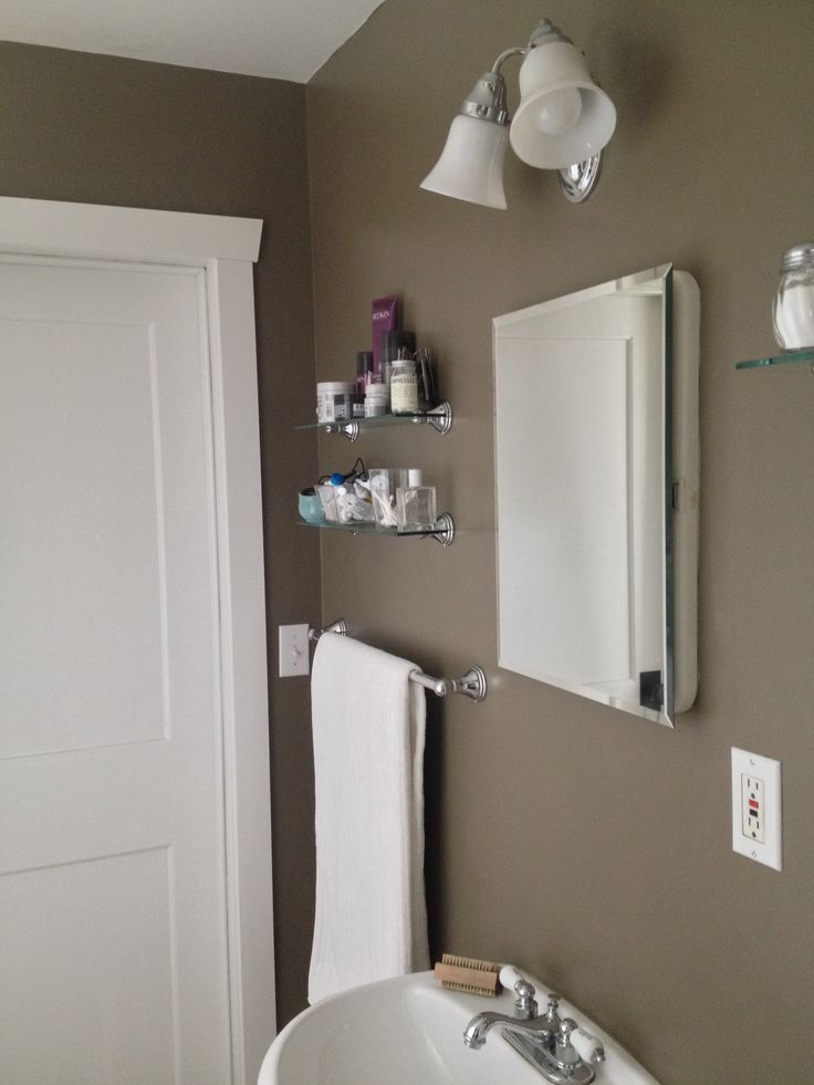 a bathroom sink sitting under a mirror next to a white door