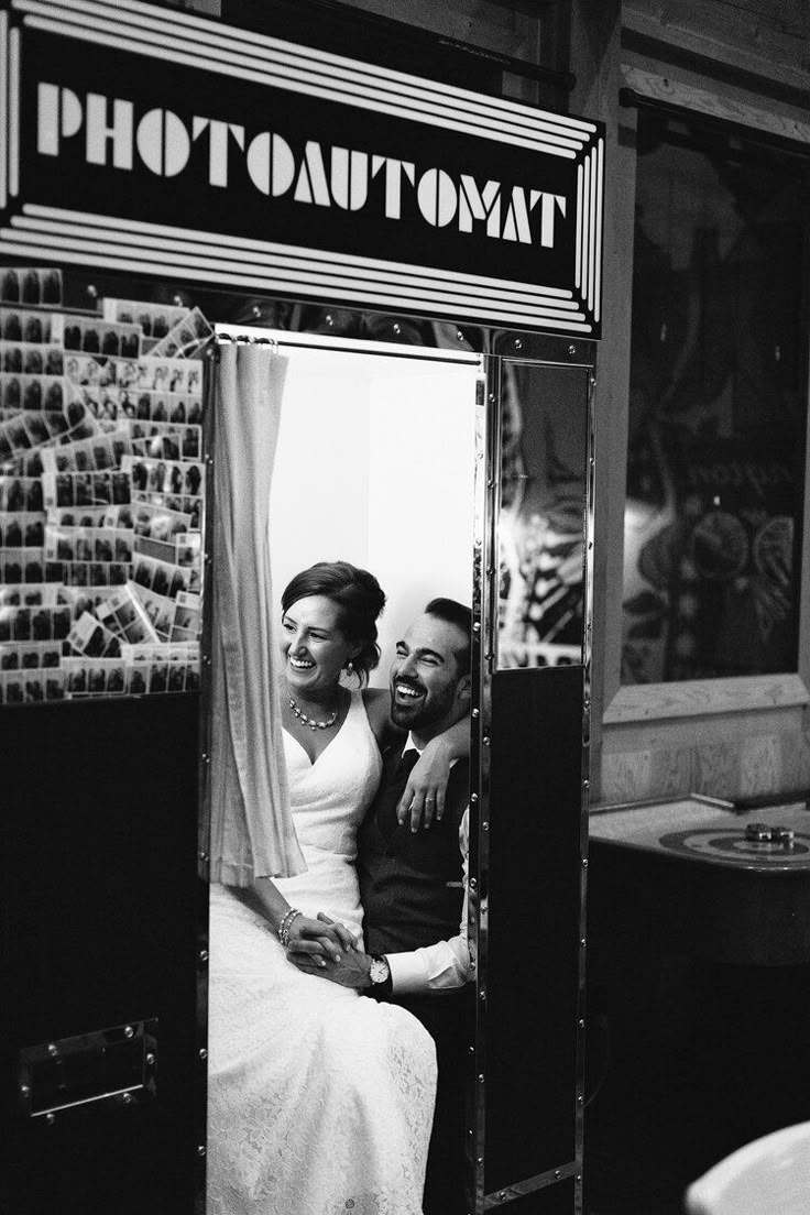 a man and woman are sitting in a booth looking at each other through the mirror