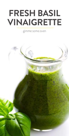 fresh basil vinaigrete in a small glass pitcher next to some green leaves