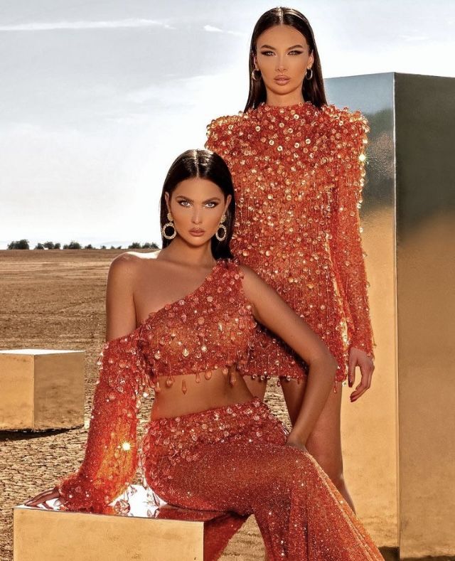 two women in orange outfits posing for the camera