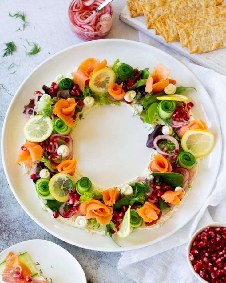 a white plate topped with a salad covered in veggies next to crackers