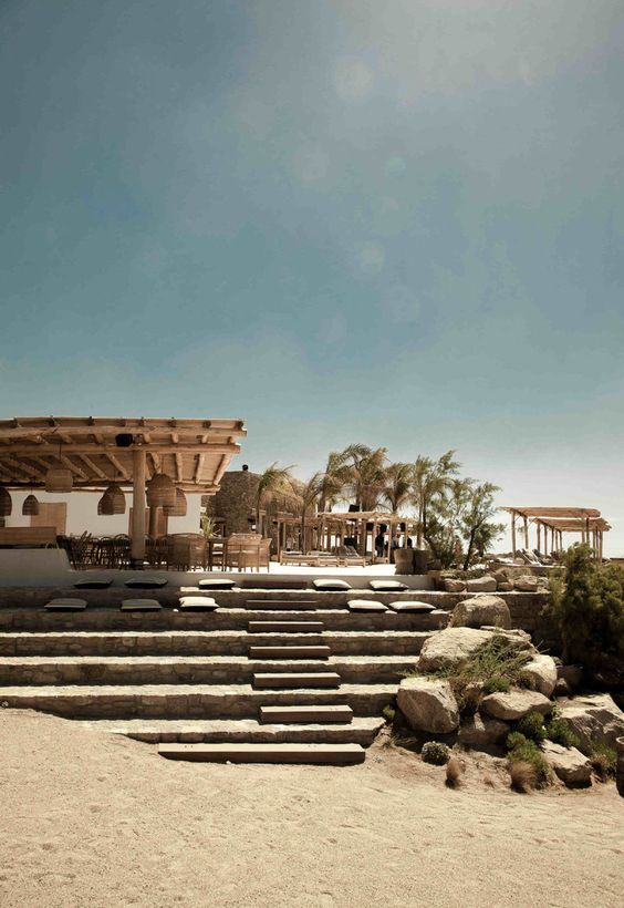 an outdoor seating area with steps leading to the beach