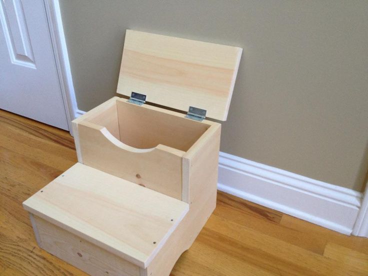 a wooden step stool sitting on top of a hard wood floor next to a door