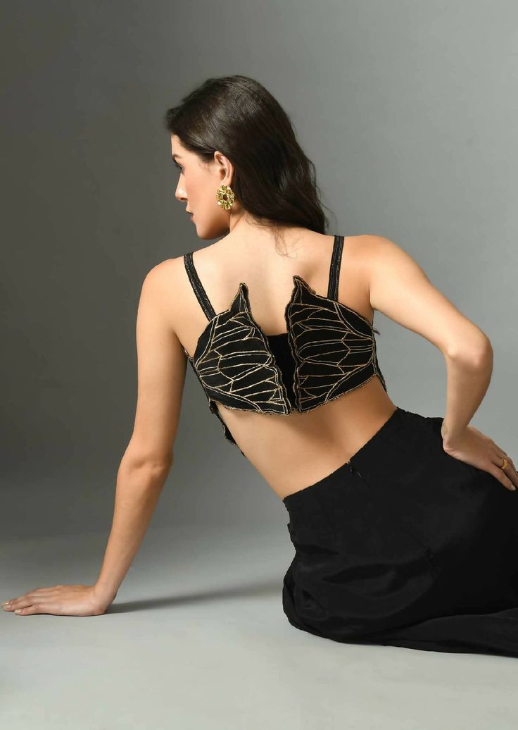 A stunning 3d bustier to make your outfit look unique. Add a touch of style to your wardrobe with the Nylah bustier. Crafted in crepe silk, it is adorned with Embroidery. The black color will add a subtle and classic touch to your look.*Note: Slight differences in the colour and embroidery is a very common occurring as each batch of fabric embroidered can never be precisely replicated. Composition and care Crepe silk Hand wash or dry clean only GARMENT MEASUREMENTS Size Bust Waist Hip Neck Shoulder Arm Hole XS 32” 26” 35” 13” 14” 13” S 34” Dupion silk 28” 37” 13.5” 14.5” 14” M 36” 30” 39” 14.5” 15” 15” L 38” 32” 41” 15.5” 15.5” 16” XL 40” 34” 43” 16.5” 16 17” Ships Worldwide from India.MADE IN INDIA