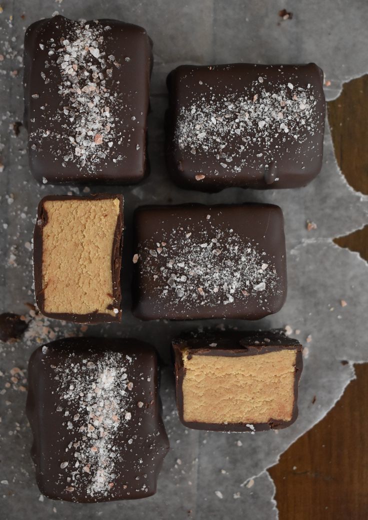 four pieces of chocolate covered dessert sitting on top of a table