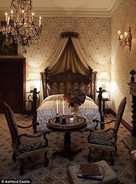 a bed room with a neatly made bed and chandelier