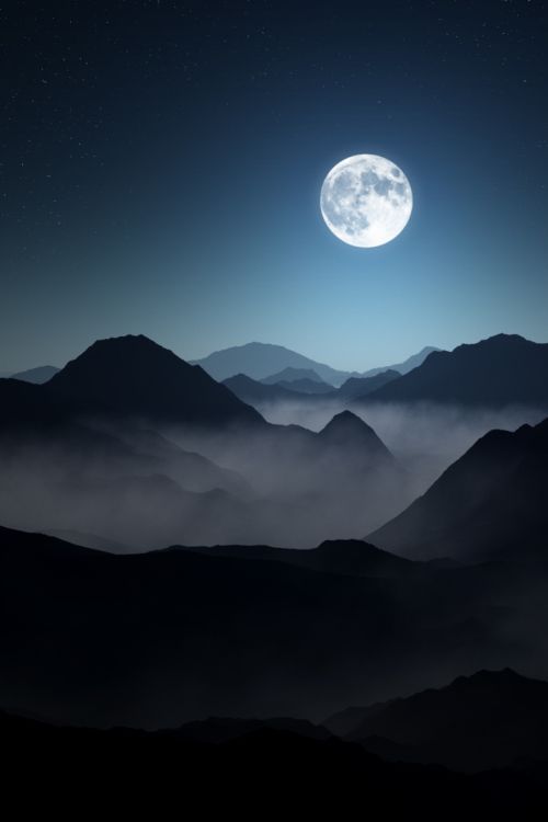 the full moon is seen over mountains in this dark night time scene with low clouds