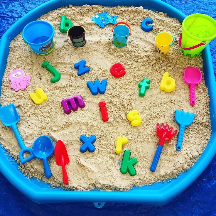 a sand tray filled with toys on top of a blue table