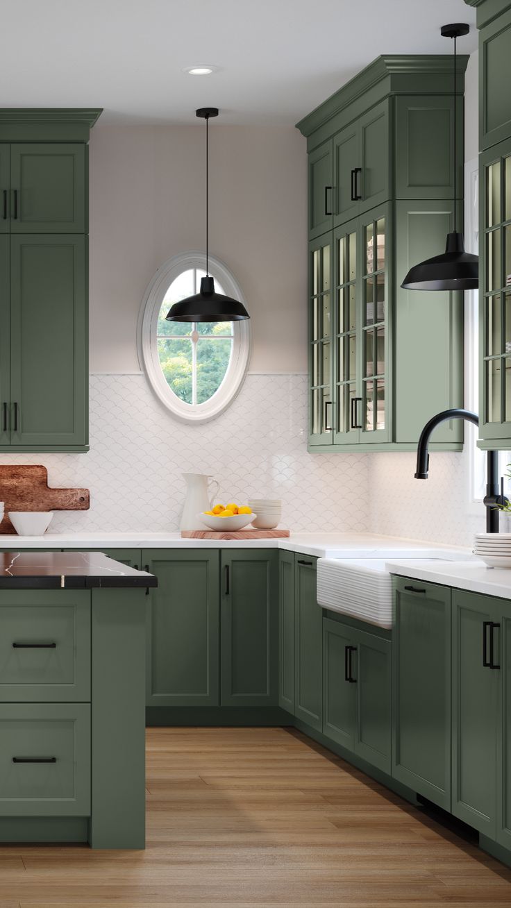 a kitchen with green cabinets and white counter tops, along with a round window over the sink